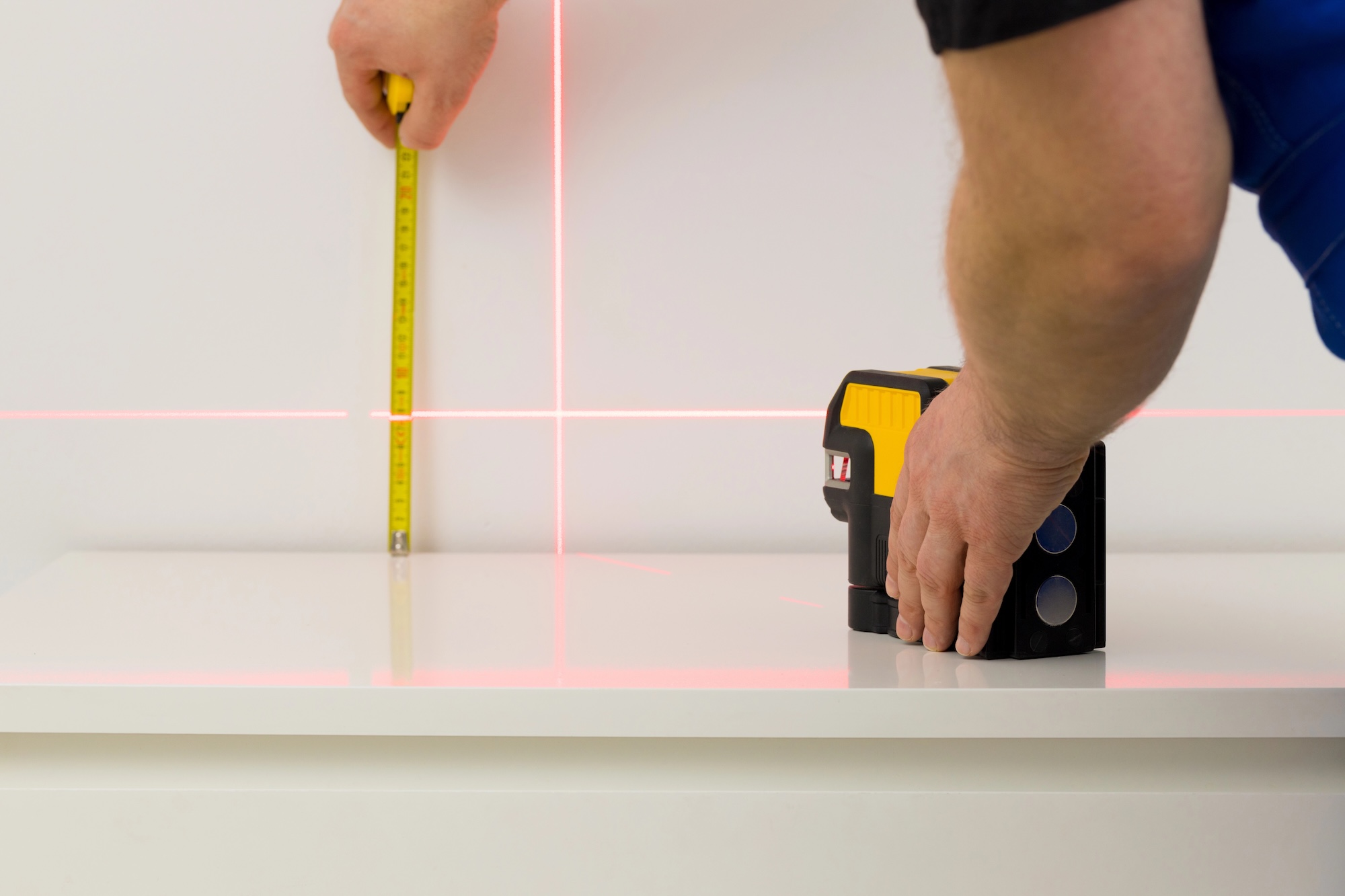 the worker marks right angles and lines during interior measurements